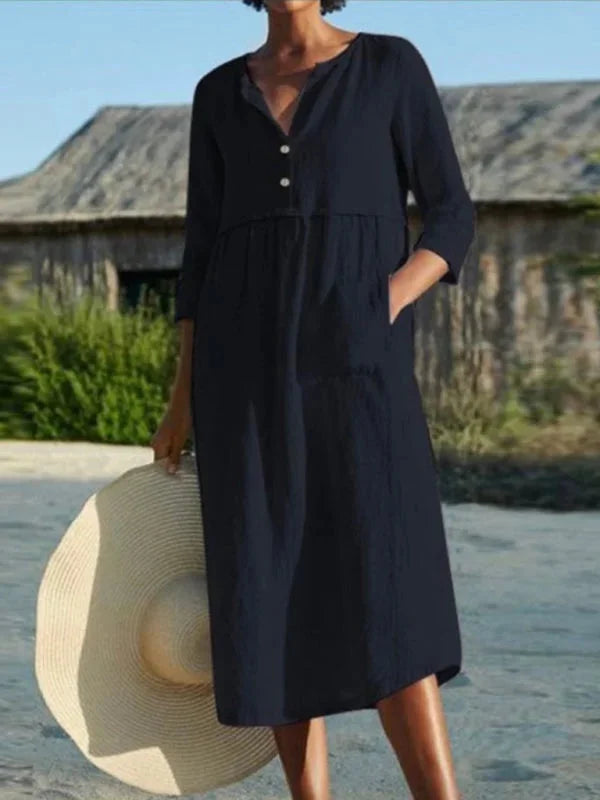 Black V-neck midi dress named Patricia with pockets, made from soft and stretchy fabric. Features a versatile and timeless…