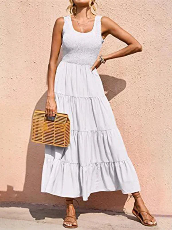 White sleeveless maxi dress with a smocked bodice and chic design. Made from breathable fabric, perfect for a summer day out.