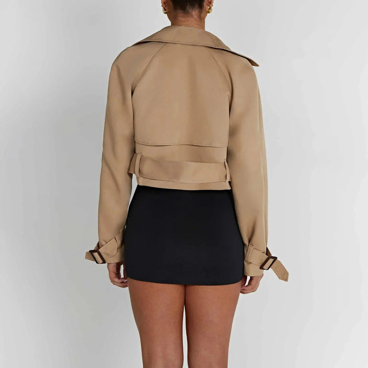 Malia trench coat in a modern cropped design, showcasing a sleek silhouette, structured collar, and belted waist in a…