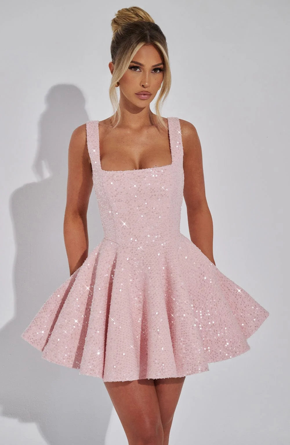 Pink fit and flare mini dress with sparkling detail. Features a flattering silhouette and shimmering fabric perfect for…