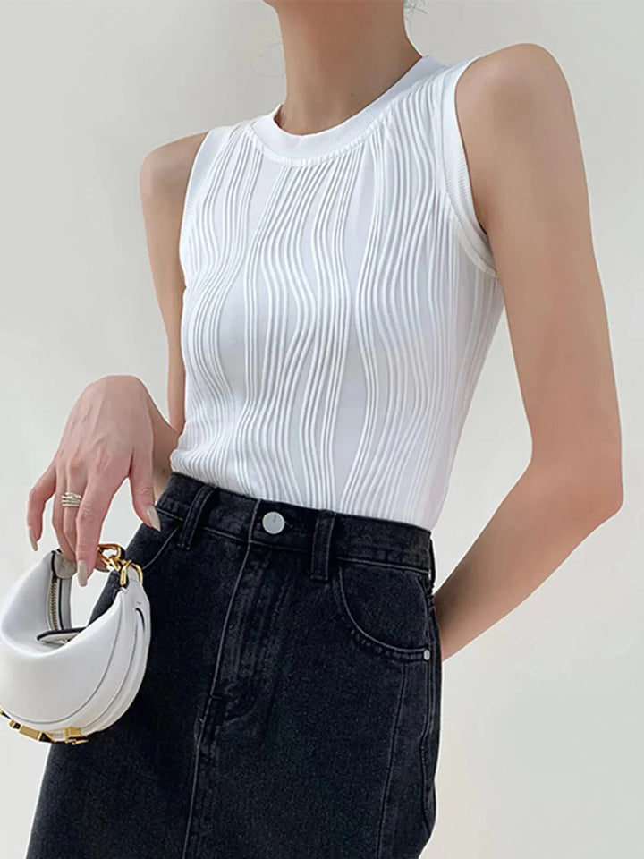 White ribbed sleeveless top, Elowyn brand. Sleek and modern design, perfect for layering. Made with soft and comfortable…