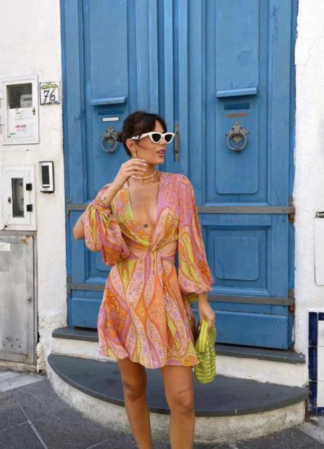 Pink and yellow patterned mini dress with V-neck design. Soft and comfortable fabric suitable for casual or semi-formal…
