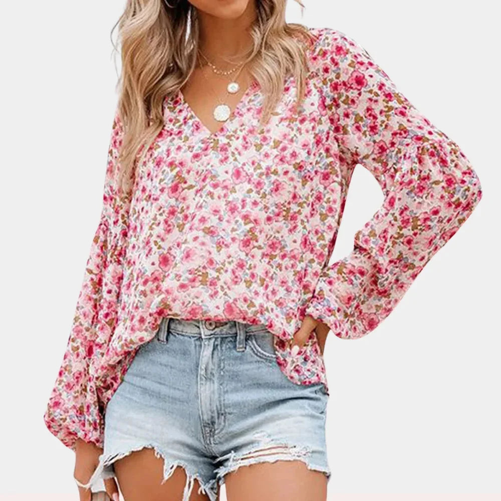 Pink V-neck blouse with bell sleeves in a trendy pattern. Soft and airy fabric for all-day comfort and style.
