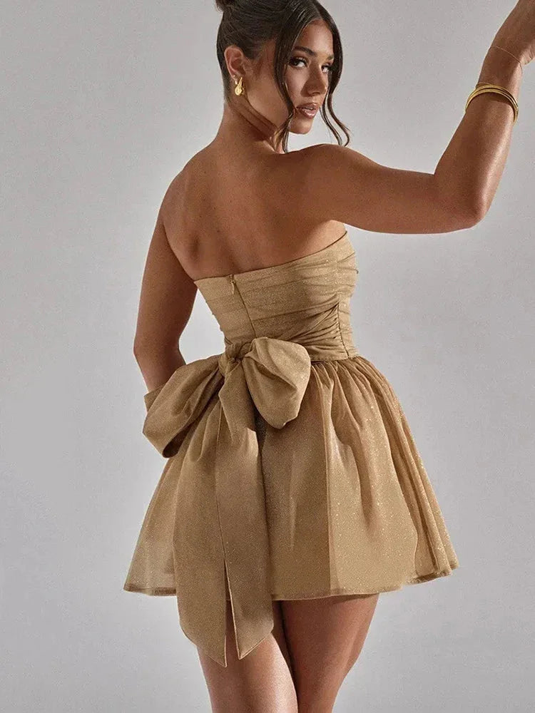 Gold mini dress with pleated design, featuring shimmering glitter accents.