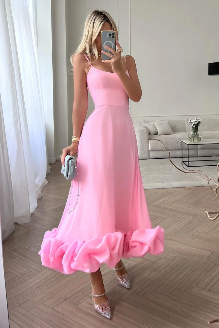 Pink sleeveless dress with ruffled hemline, perfect for summer days. Made of lightweight fabric with a flowy design.