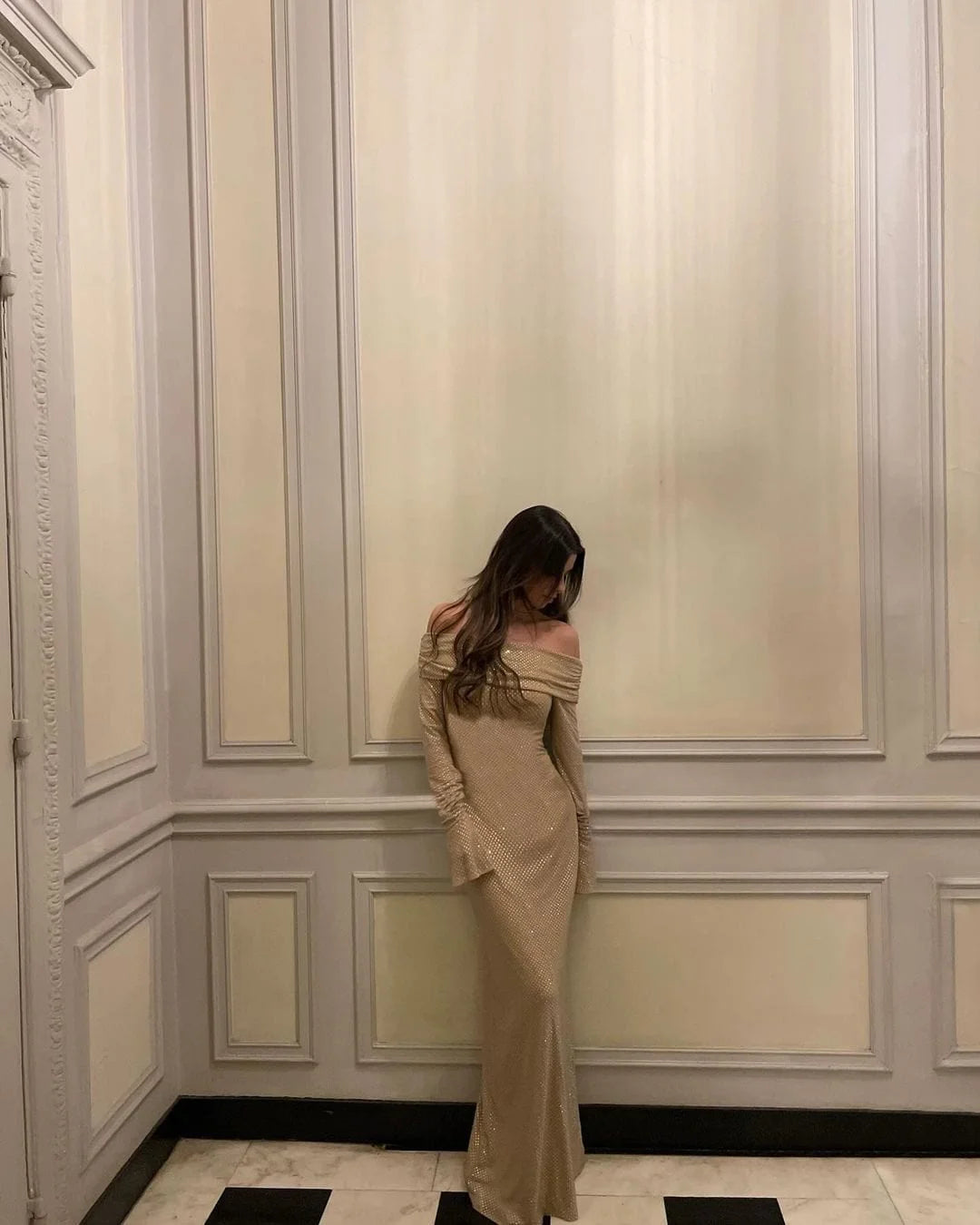 Striking shimmering long dress with elegant shoulder details, perfect for special occasions.
