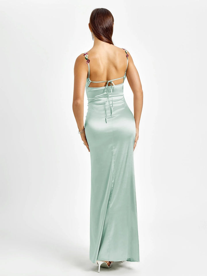 Sleeveless fitted maxi dress named Kenleigh with intricate embellishments on the bodice and a flowing skirt, perfect for elegant…