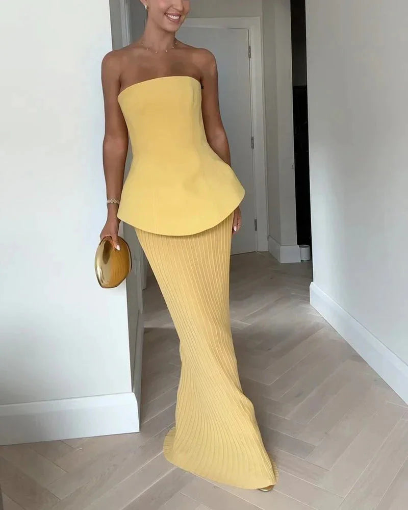 Yellow strapless peplum top with ribbed skirt, featuring a stretchy knit material with a figure-flattering design.