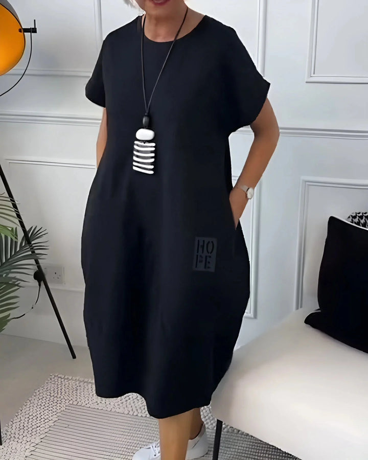 Black Kassandra dress: sleek and versatile, made with soft, stretchy fabric for a comfortable fit. Subtle design details give a…