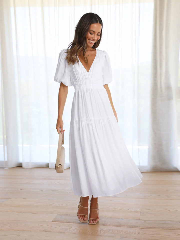 White midi dress with a V-neck and elastic waist from Weslynn. Made of soft fabric with a chic design perfect for casual or…