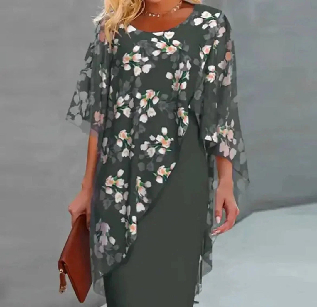 Green floral shift dress with sheer overlay, perfect for spring. Flattering and elegant design with delicate flower pattern.
