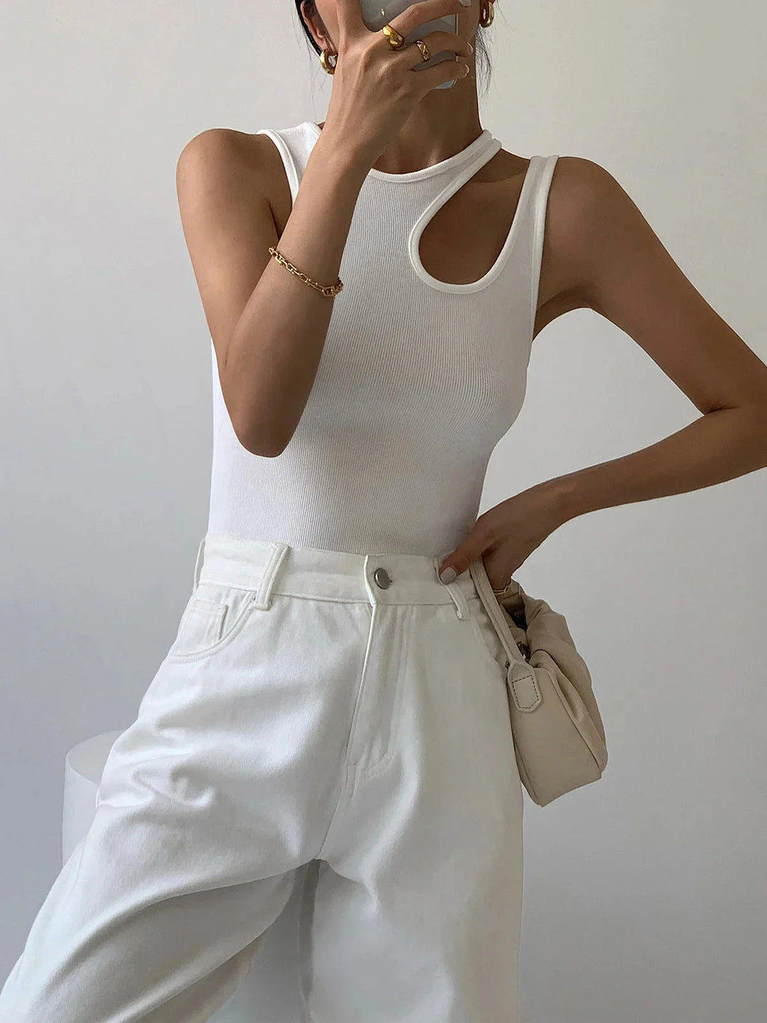 "Black sleeveless top featuring asymmetric ribbed knit design for a modern and edgy look."