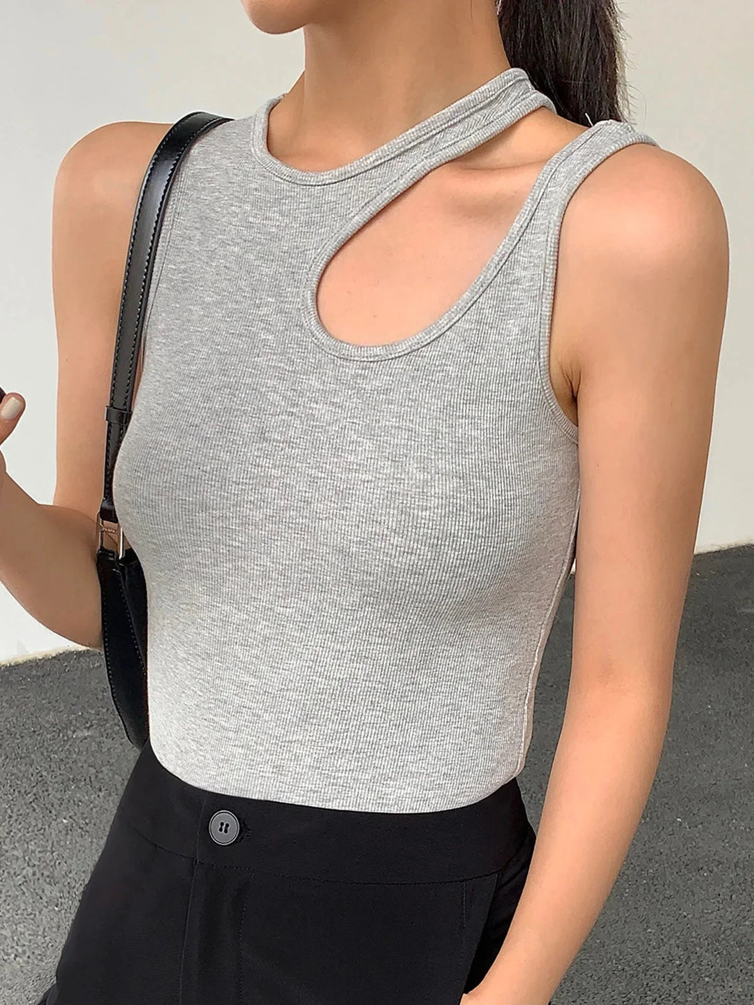 Light grey ribbed knit sleeveless top with asymmetric design. Texture adds interest to outfit.