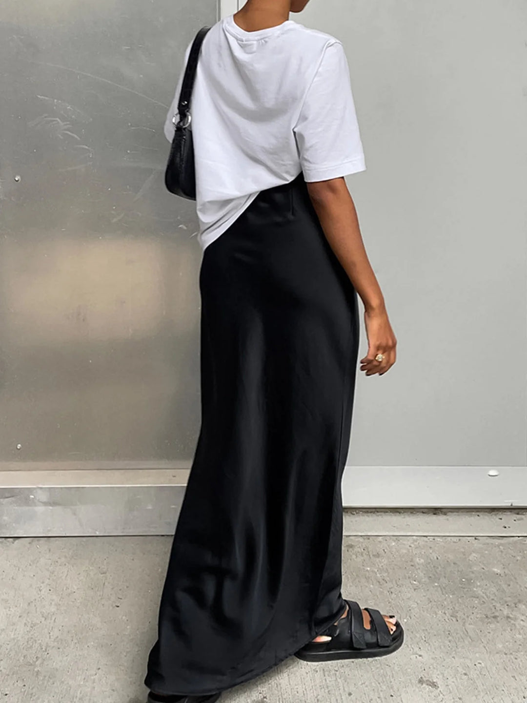 Flowy satin maxi skirt in a deep navy color, featuring a high waist and elegant drape design, perfect for a formal evening…