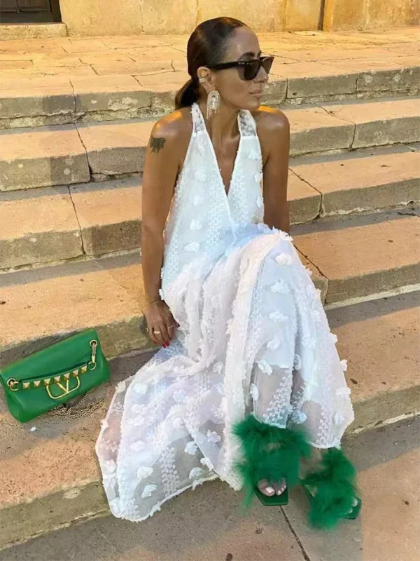 Zola halter neck maxi dress showcasing intricate floral detailing on light, flowing fabric perfect for a summery daytime…