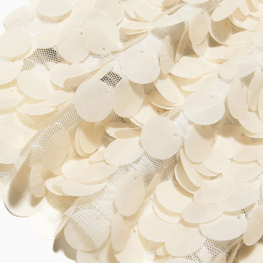 Ivory sequin mini skirt with shimmering detailing on soft fabric.